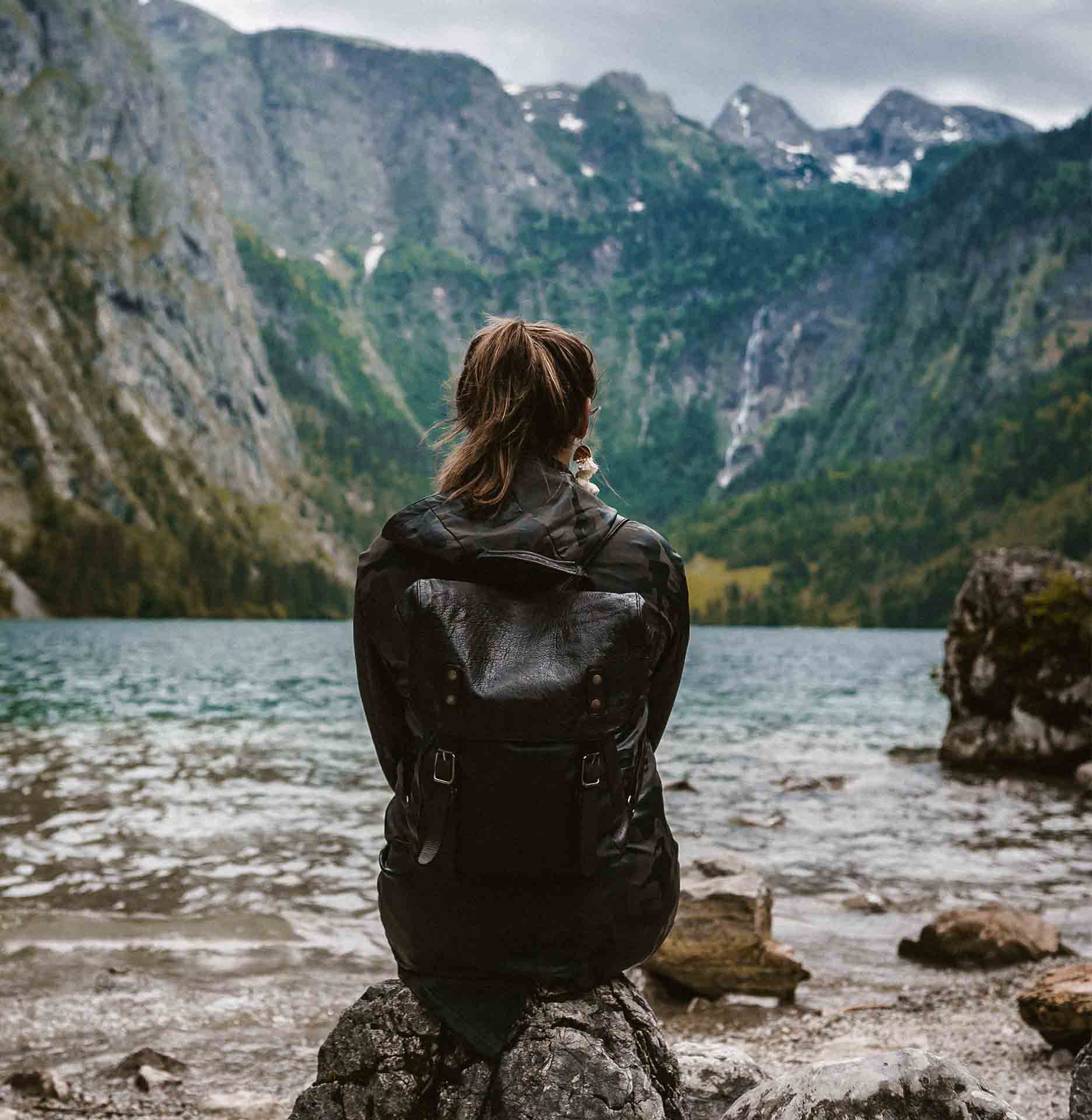 picture of a woman with her back turned on the shore of a fjord